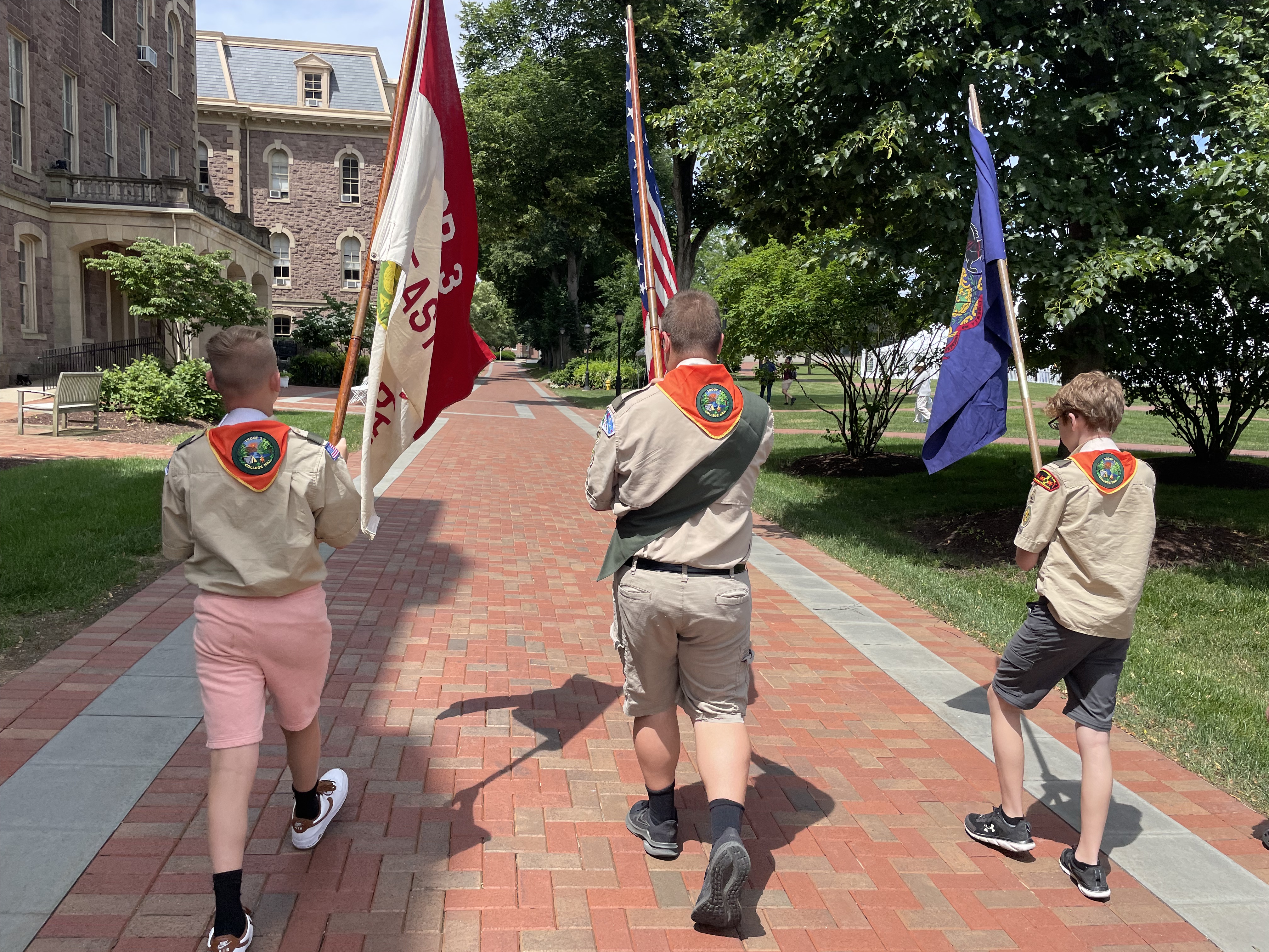 Three scouts carrying flags (left to rightL troop flag, united states flag, PA state flag