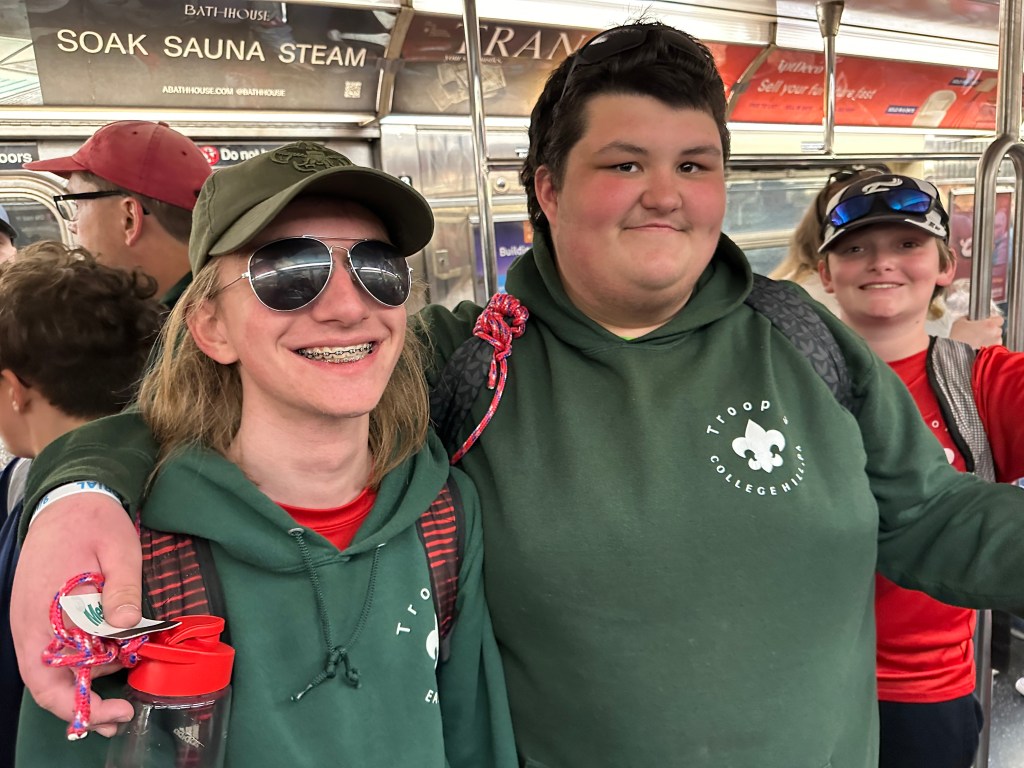 A clsoe up of two scouts on the subway